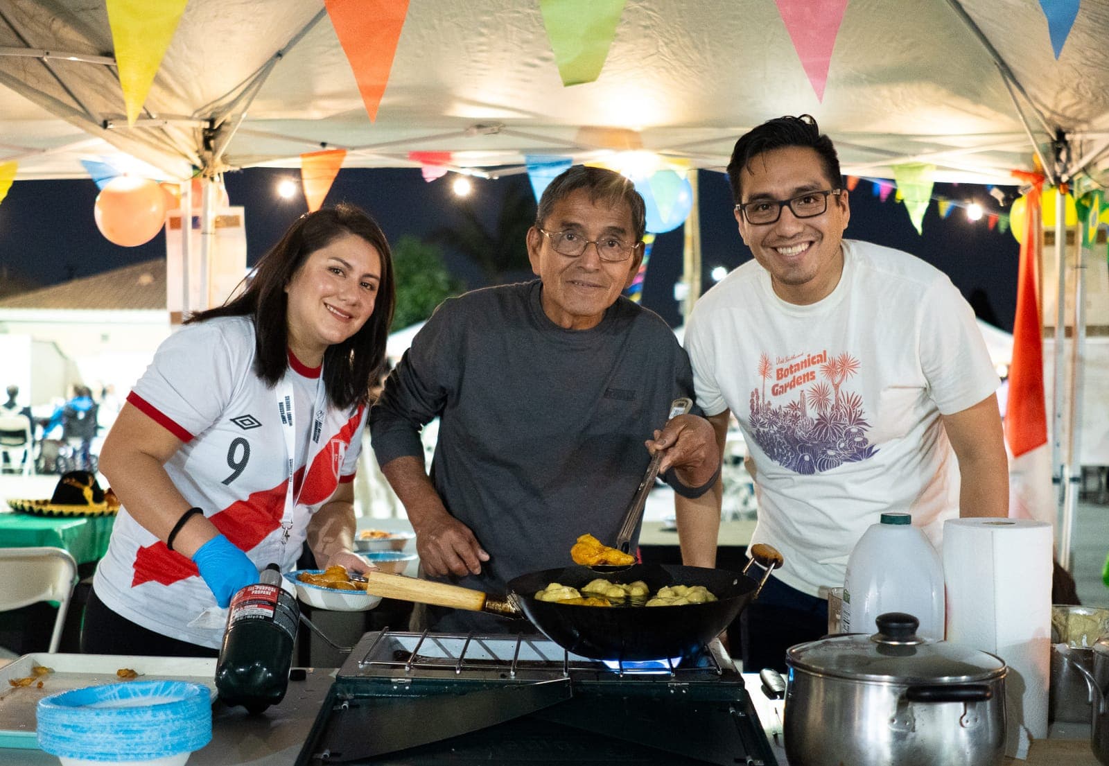 Volunteers cooking together at an All Nations fundraiser